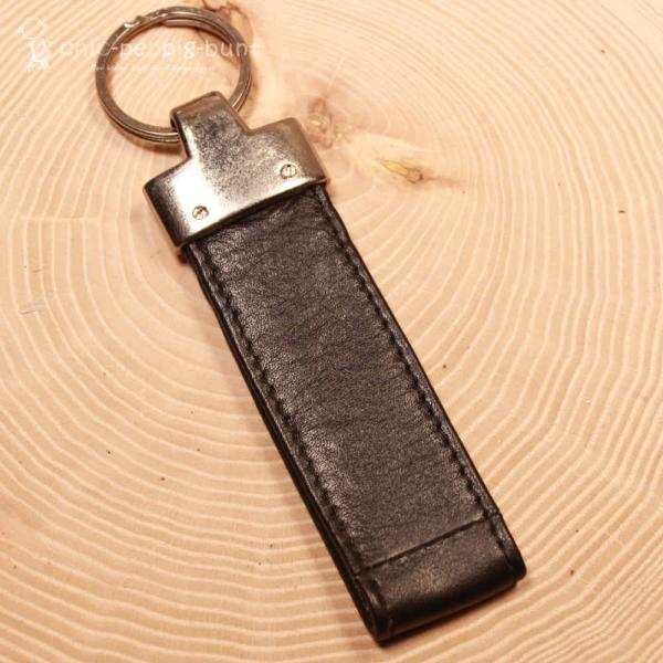 Leder Taschenbaumler destino befestigt an einer Reisetasche zur Größenveranschaulichung.